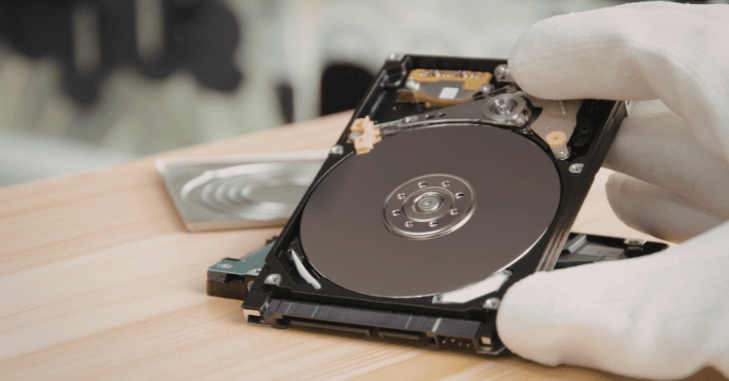 Hands installing an internal drive into a game console